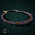 My Store SAXRelics amethyst beaded necklace with gold-tone spacers and a toggle clasp on a dark textured background.