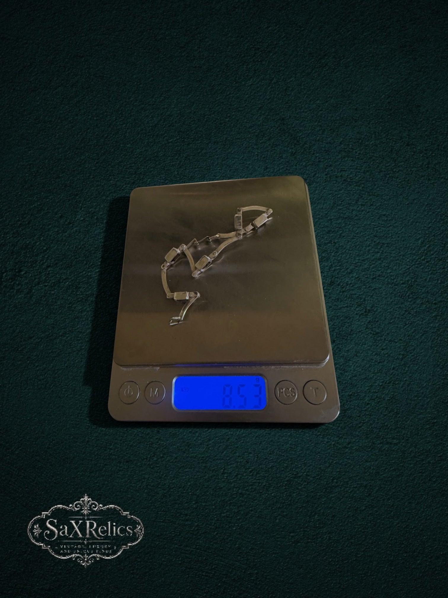 My Store SAXRelics vintage-inspired amethyst link bracelet resting on a digital scale against a dark green background.