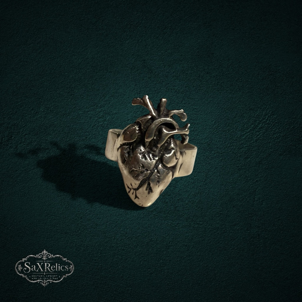 My Store silver-toned anatomical heart statement ring with intricate realistic details on a dark textured background.