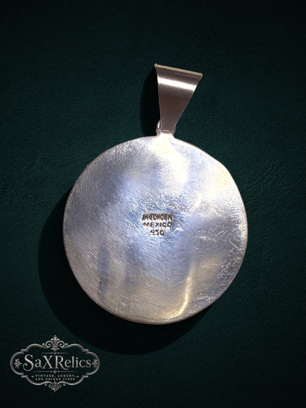 .950 silver Aztec calendar pendant back view showing Mexico hallmark on a dark green background