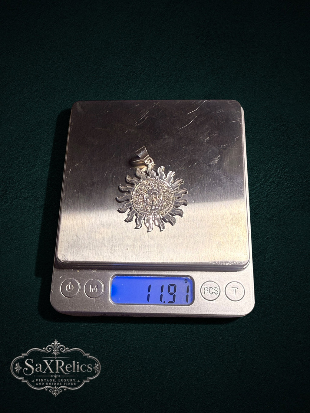 .950 silver Aztec calendar sun pendant weighing 11.91 grams on a digital scale