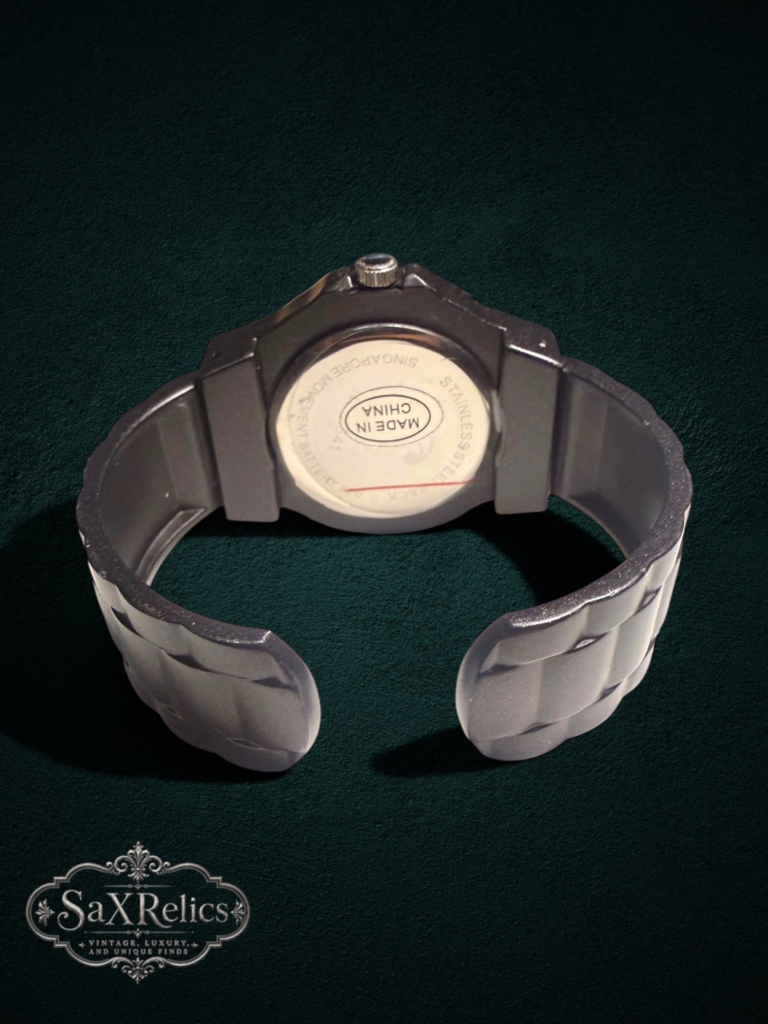 My Store black cuff-style quartz wristwatch showing the stainless steel back casing and open bracelet design