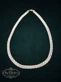 Braided sterling silver multi-strand chain necklace with a textured weave on a dark green background