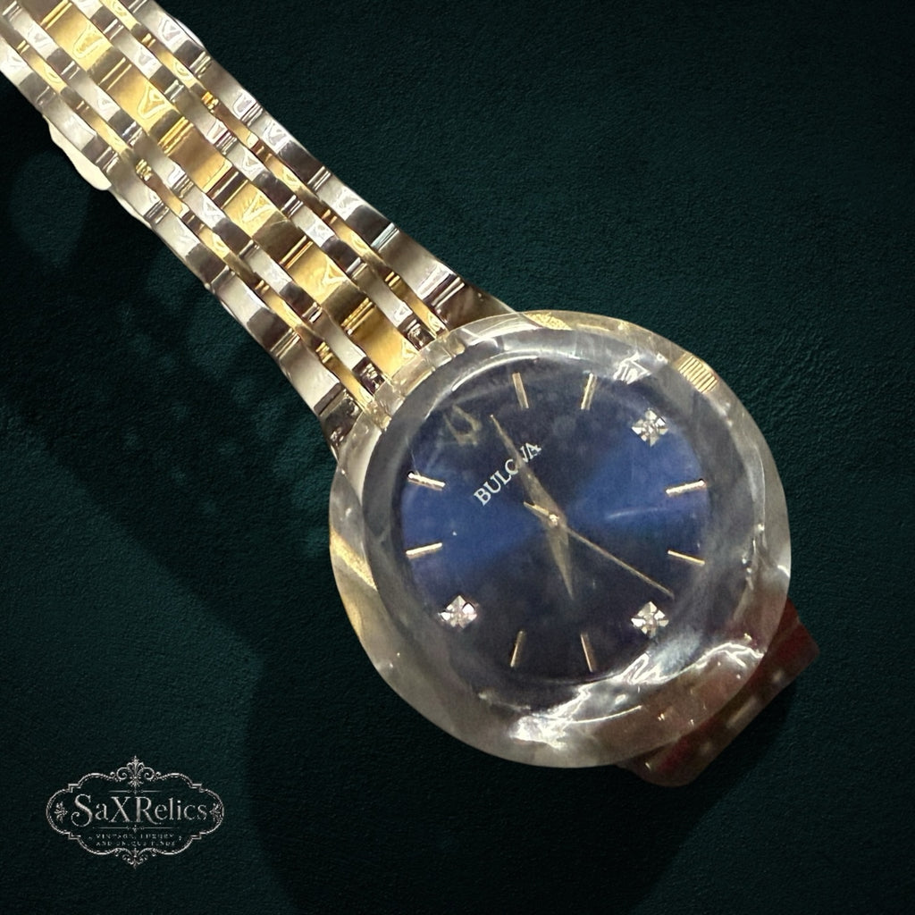 My Store Bulova stainless steel watch with a deep blue dial, diamond markers, and a two-tone gold and silver bracelet.