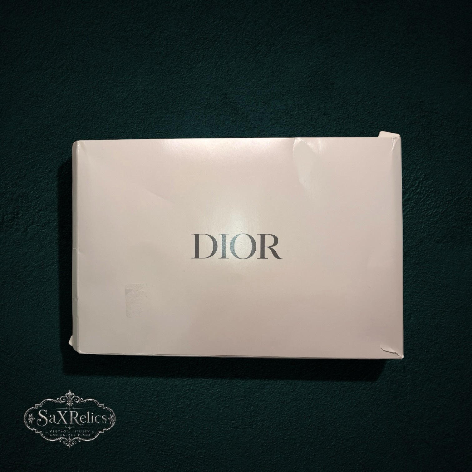 My Store Christian Dior white branded presentation box for luxury accessories on a dark textured background