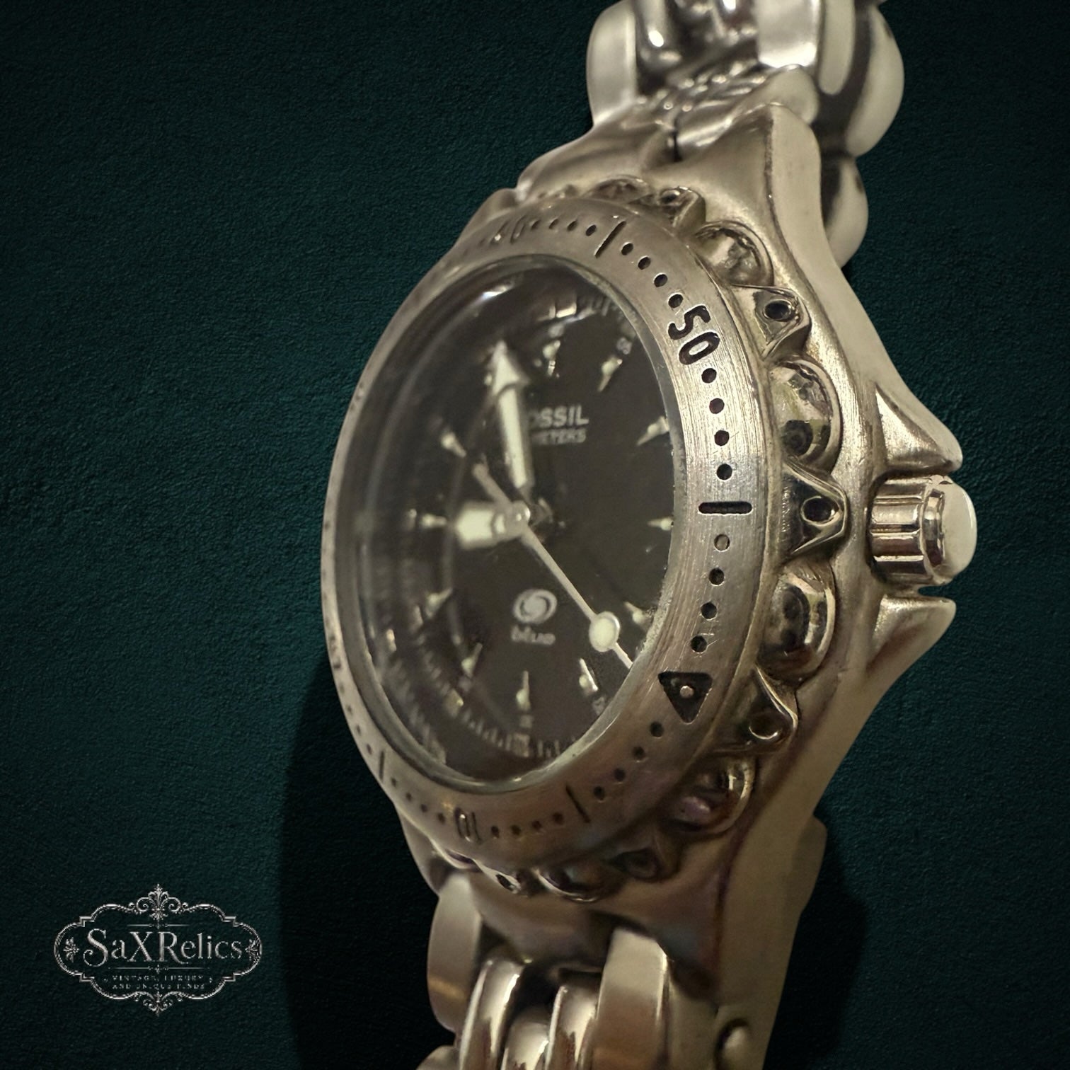 My Store Fossil Blue stainless steel analog watch with a black dial and textured bezel on a link bracelet