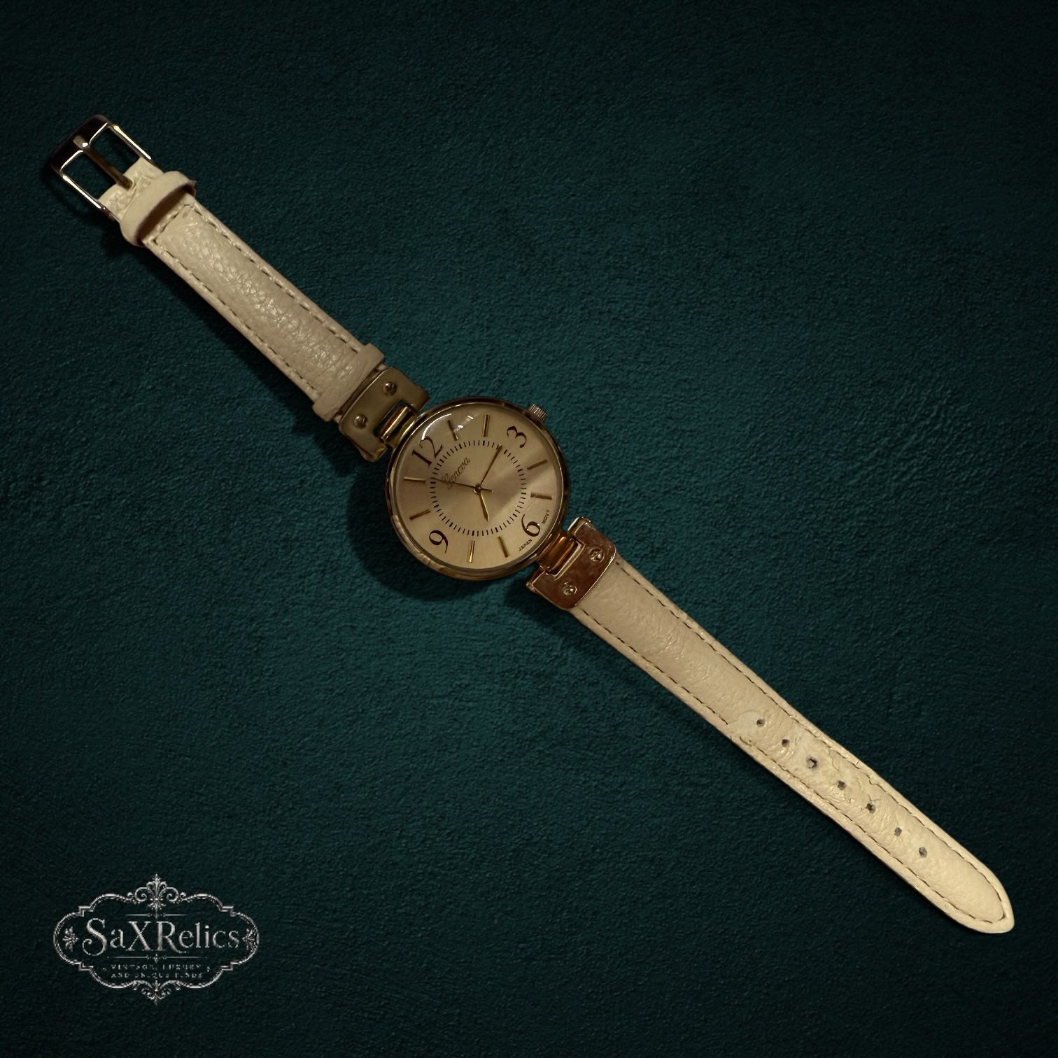 My Store Geneva analog wristwatch with a gold-tone round case and a cream-colored textured leather strap.