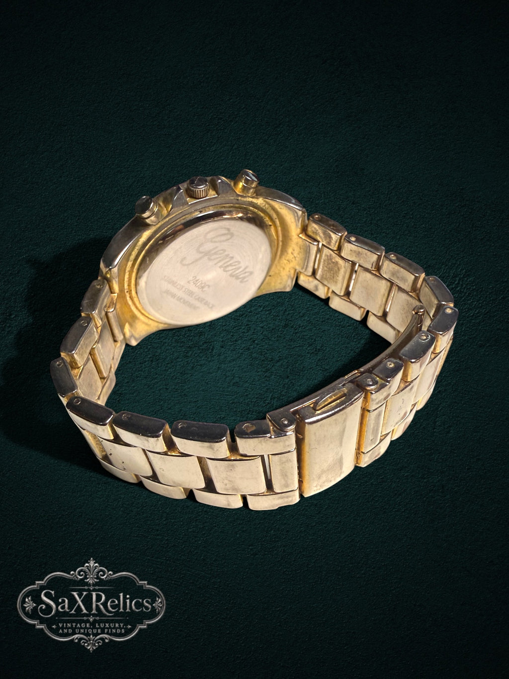 My Store gold-tone Geneva chronograph watch showing the engraved stainless steel case back and link bracelet