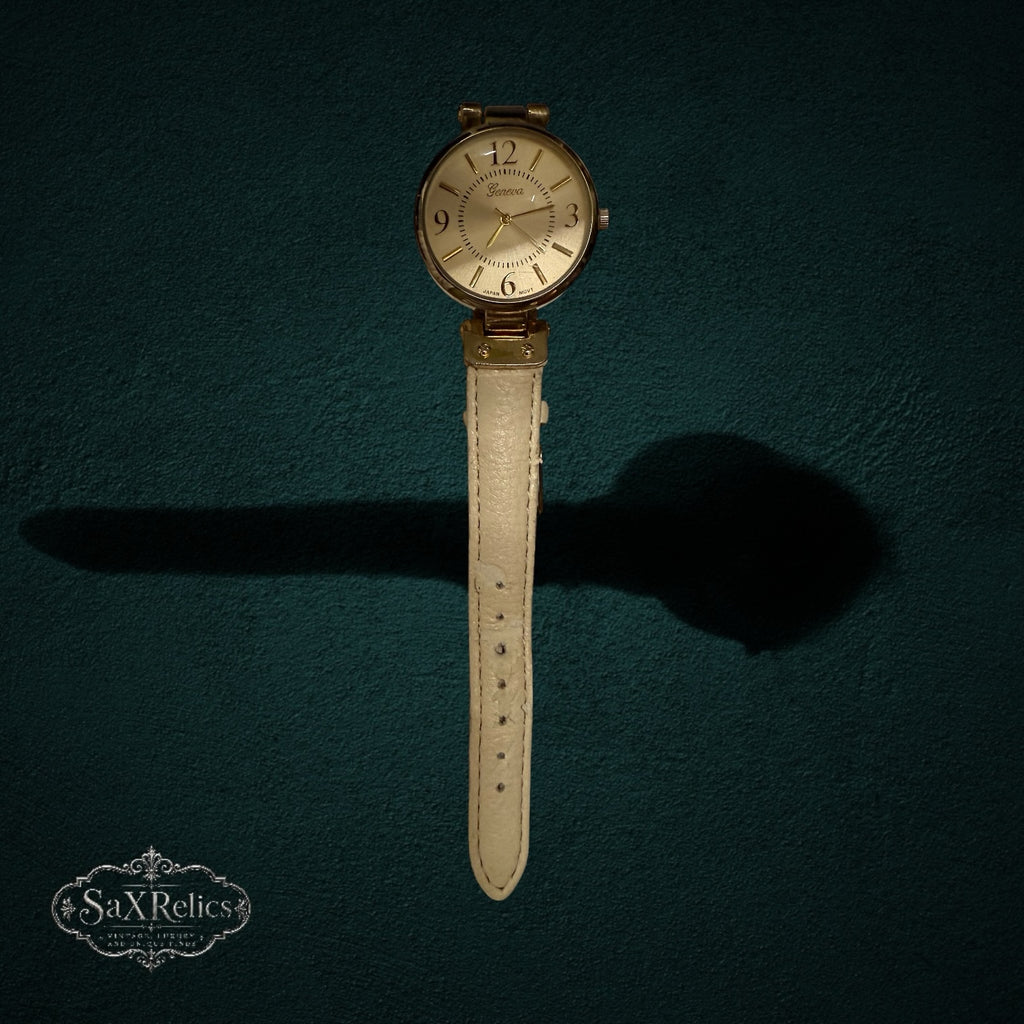 My Store Geneva analog wristwatch featuring a gold-tone round case and a cream-colored textured leather strap.