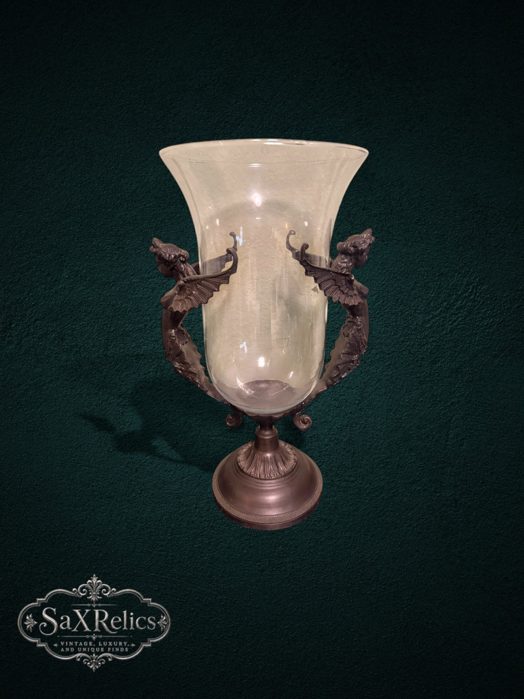 My Store decorative glass vase featuring a clear hurricane shade held by an ornate bronze metal stand with winged figures