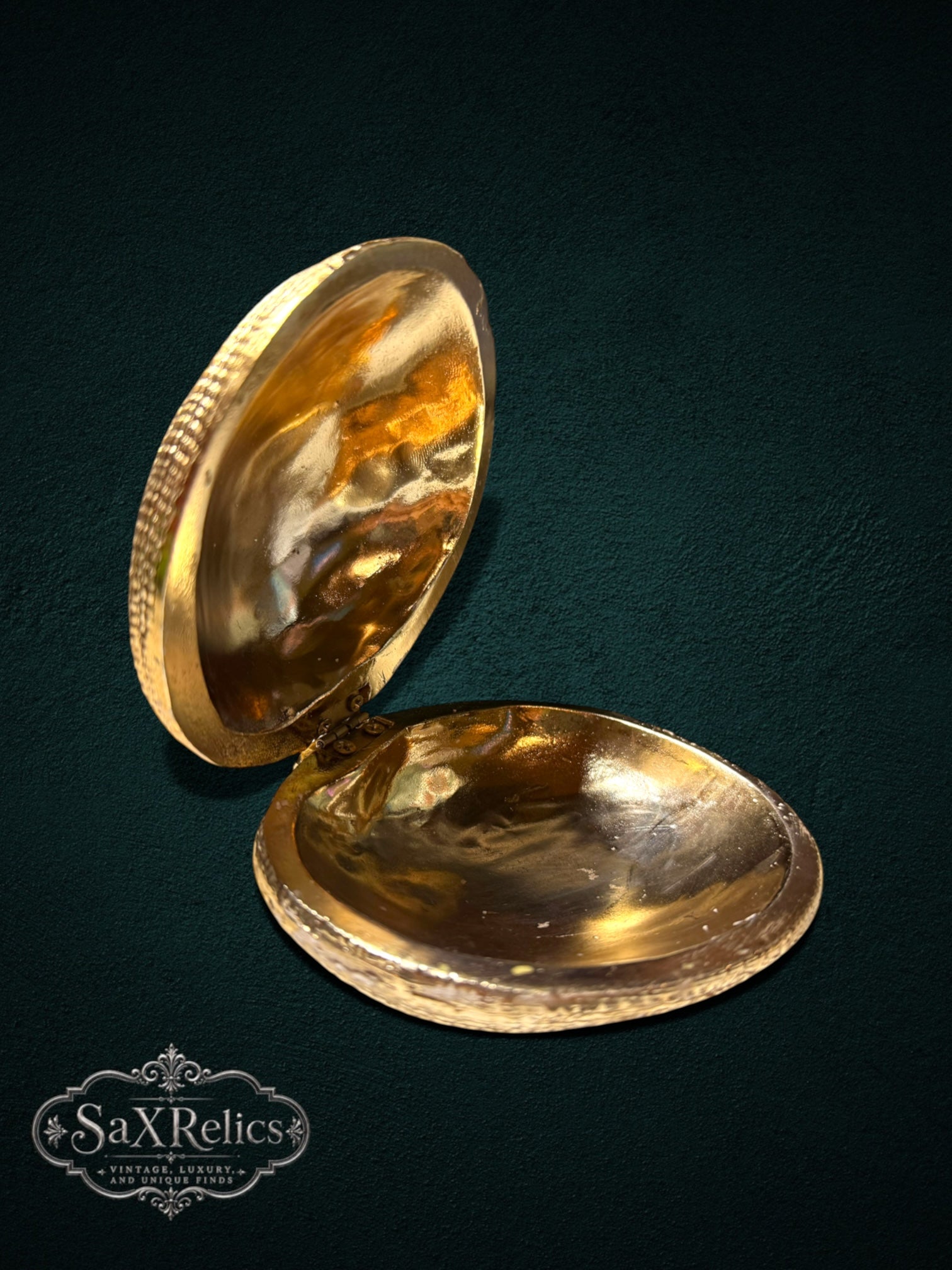 My Store gold-tone clam shell trinket box with a textured exterior and polished reflective interior on dark background