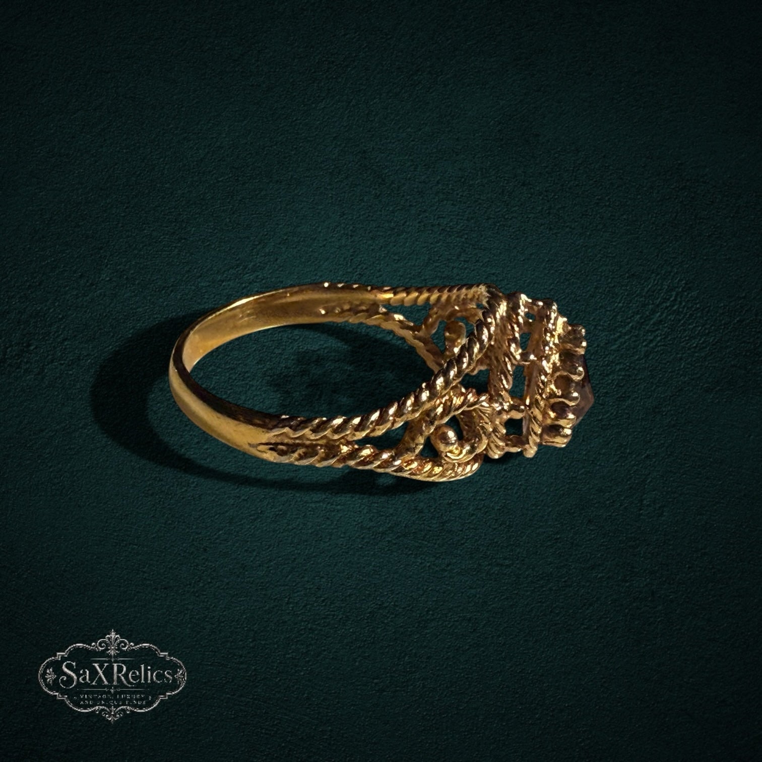 My Store SAXRelics gold ring with a pear-cut gemstone, featuring an ornate twisted rope band and filigree details.