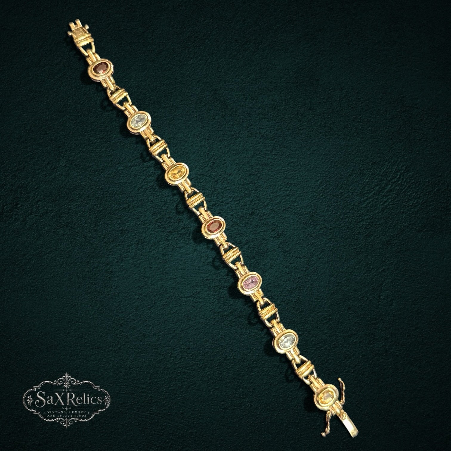 My Store SAXRelics vintage-inspired gold-tone link bracelet featuring oval-cut multi-colored gemstones on a dark background