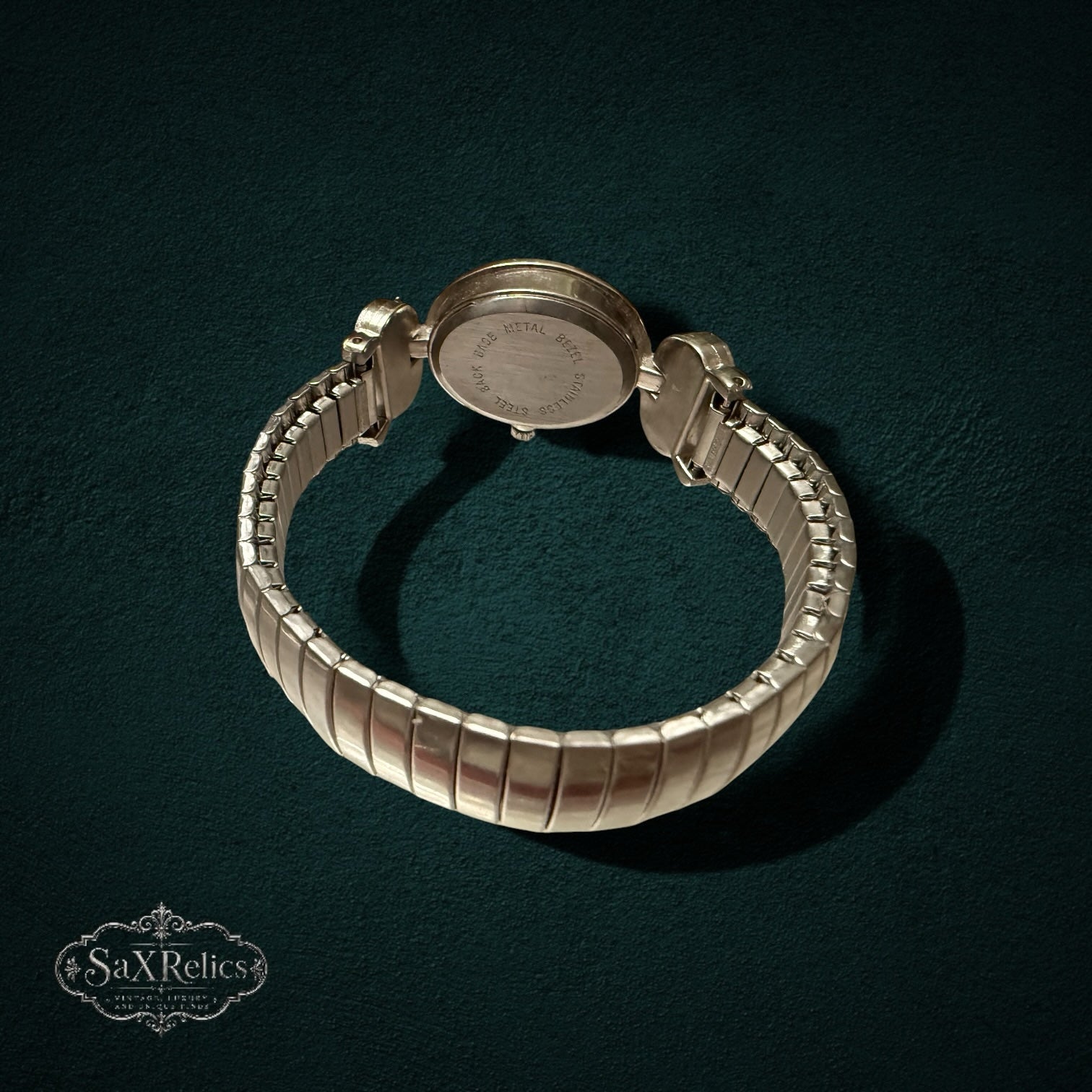 My Store vintage-inspired gold-tone analog watch with heart accents and a flexible expansion band, back view.