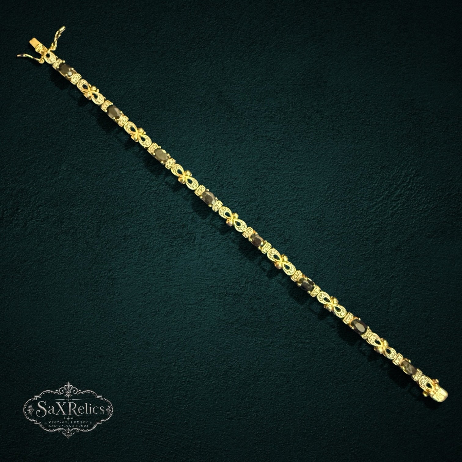My Store SAXRelics gold-toned sterling silver link bracelet with oval gemstones and pave-set stones on dark background