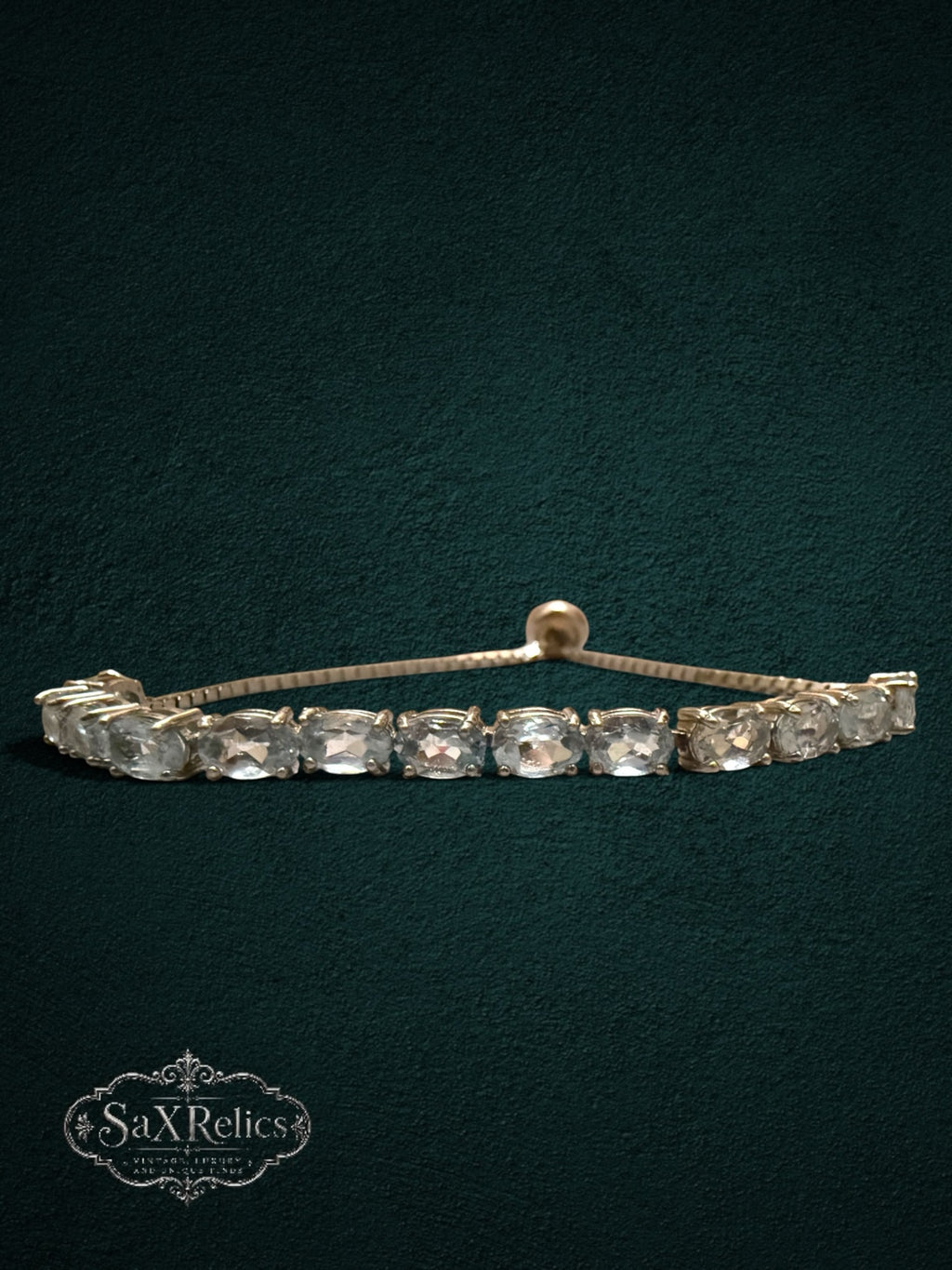 My Store gold-tone tennis bracelet featuring clear oval-cut crystals and an adjustable bolo-style sliding clasp.