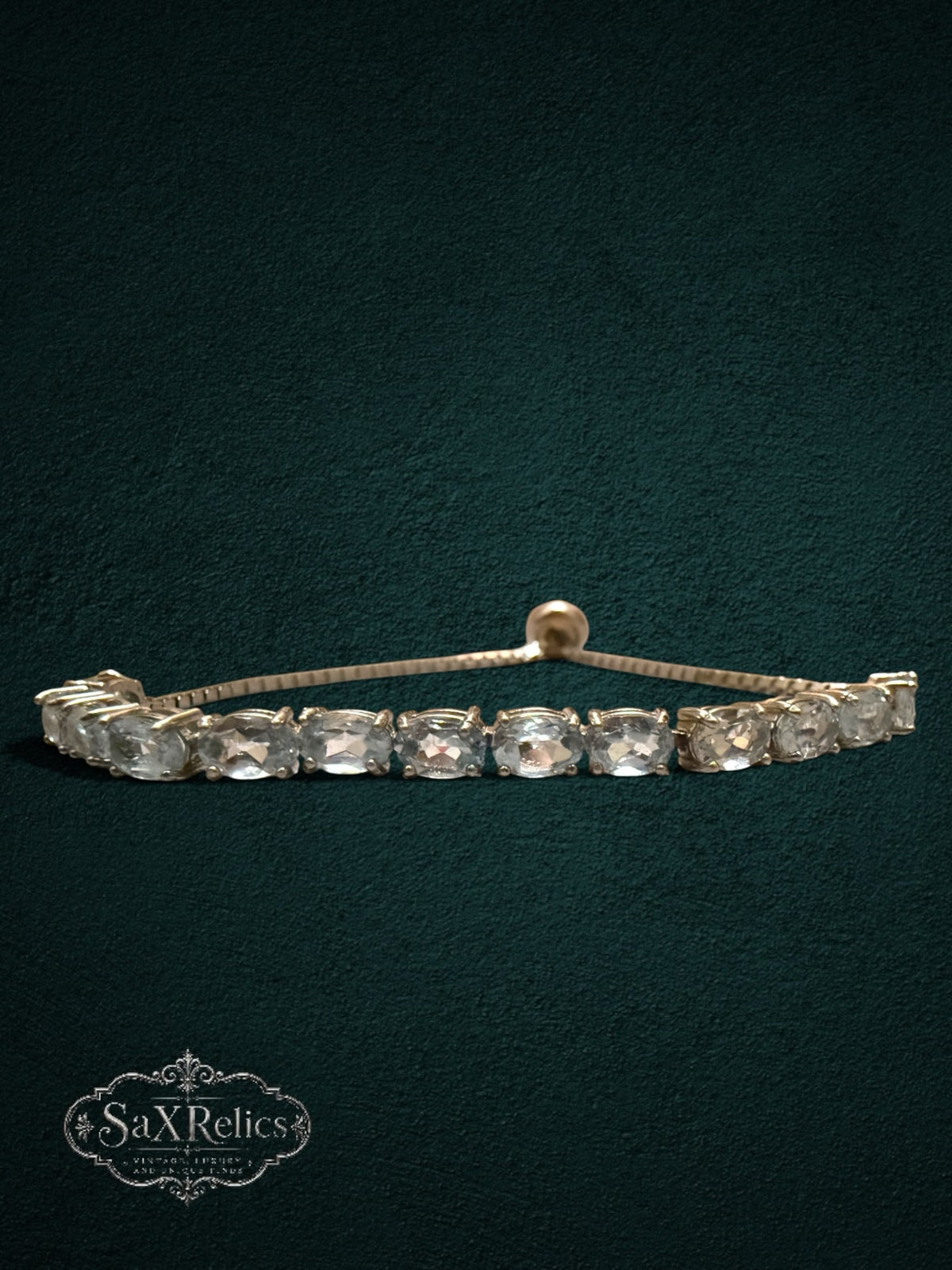 My Store gold-tone tennis bracelet featuring clear oval-cut crystals and an adjustable bolo-style sliding clasp.