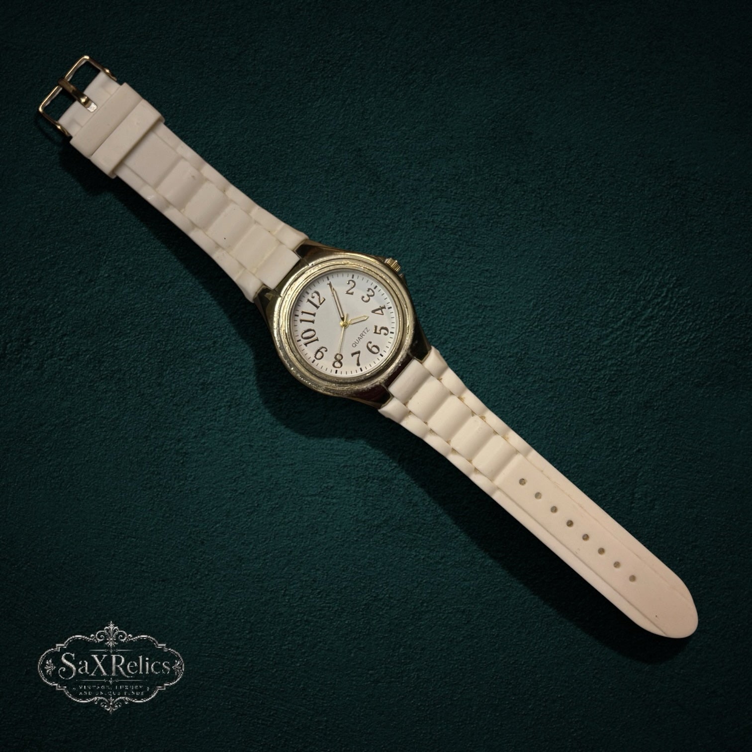 SaX Relics gold-tone bezel quartz watch showing the white dial and numeral markers