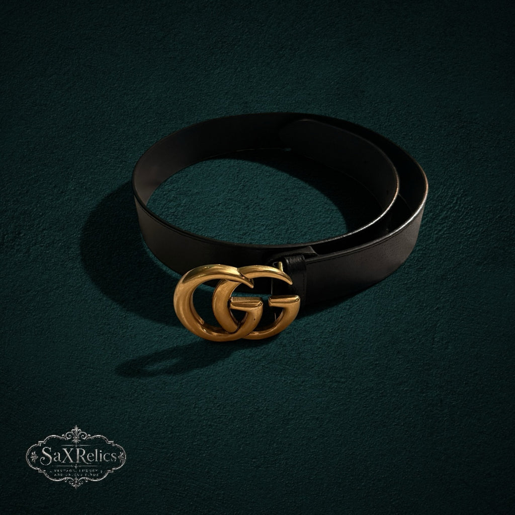 My Store black leather Gucci belt featuring an iconic interlocking GG buckle in brushed antique gold on dark background