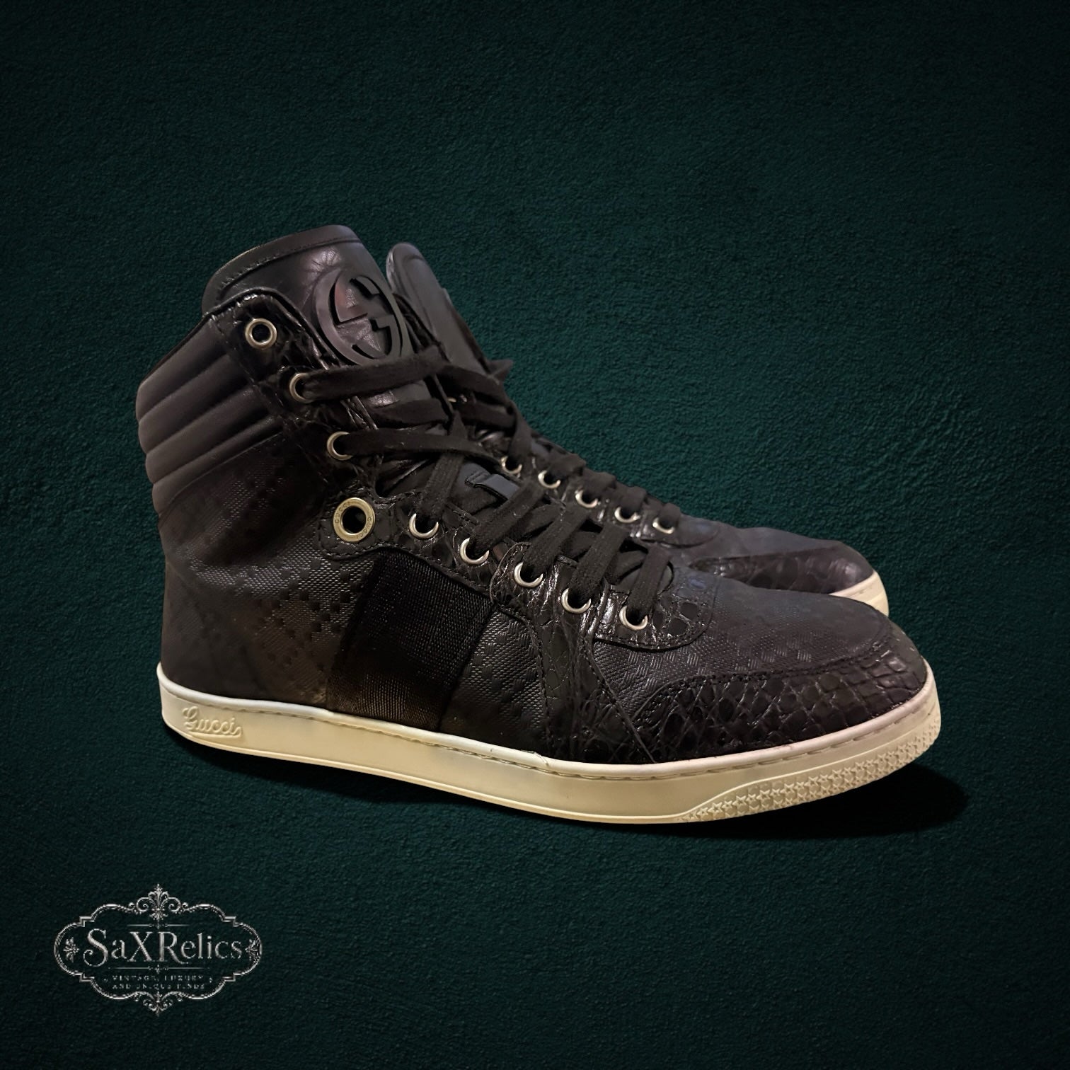 My Store Gucci black leather high-top sneakers featuring a GG monogram pattern, textured overlays, and a rubber sole.