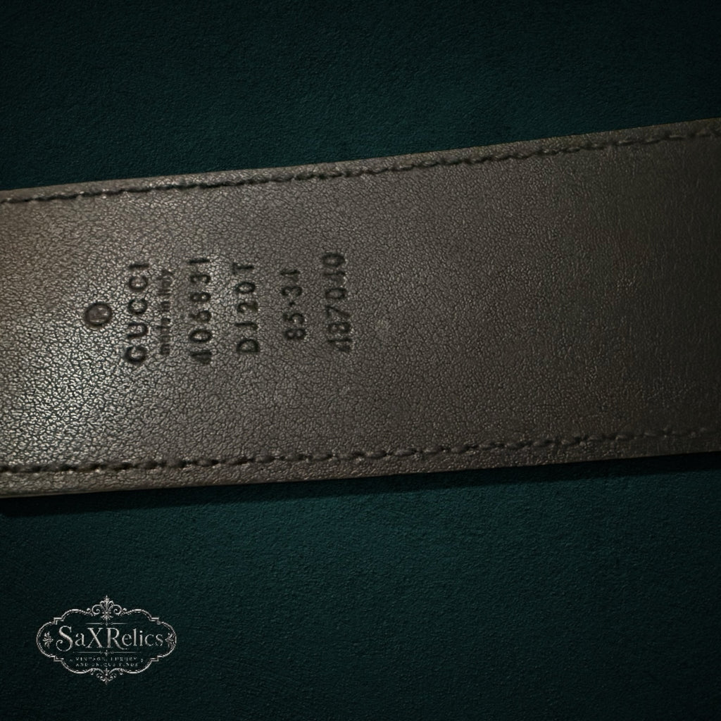 My Store GUCCI leather belt interior showing embossed brand logo, serial number, and size details on black leather.