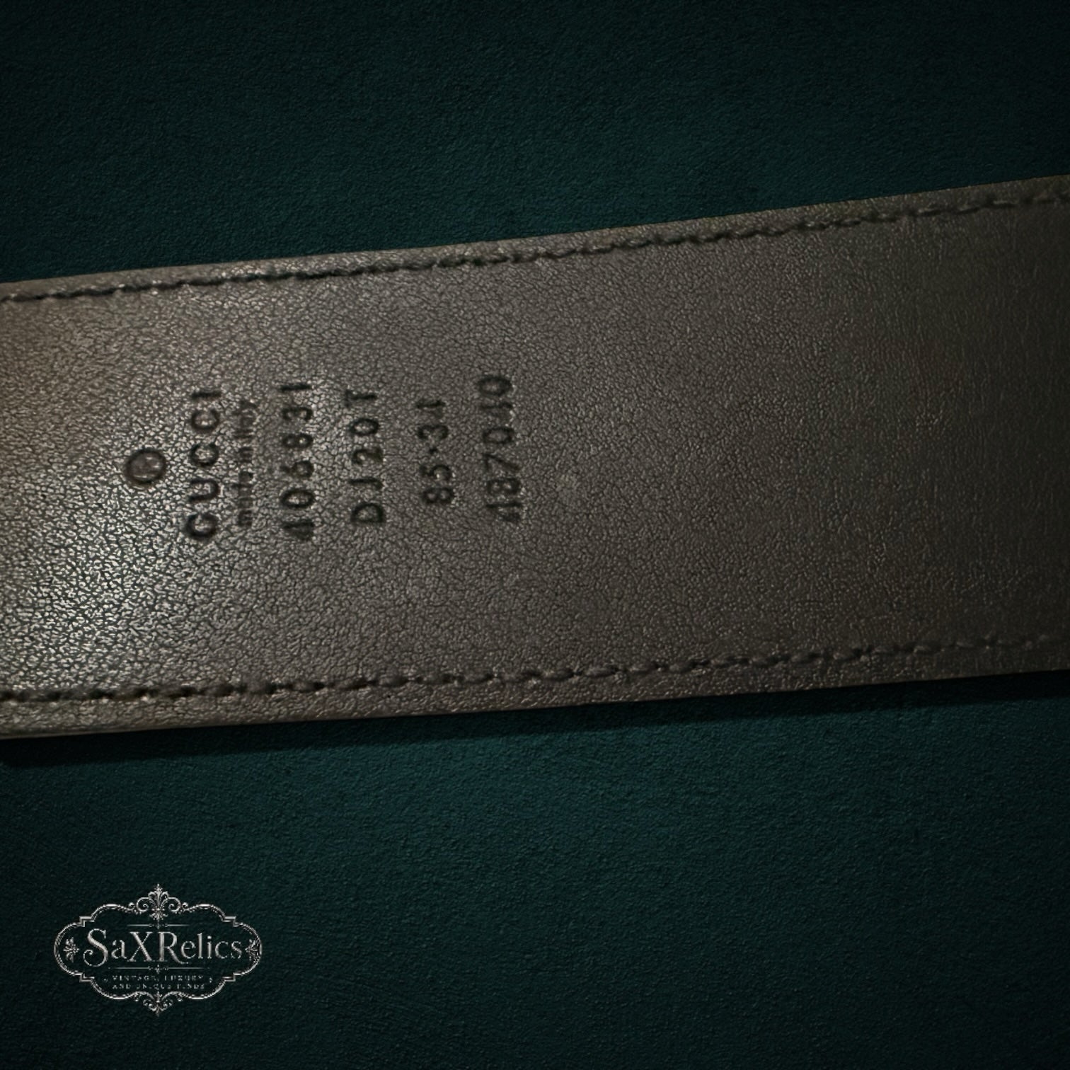 My Store GUCCI leather belt interior showing embossed brand logo, serial number, and size details on black leather.