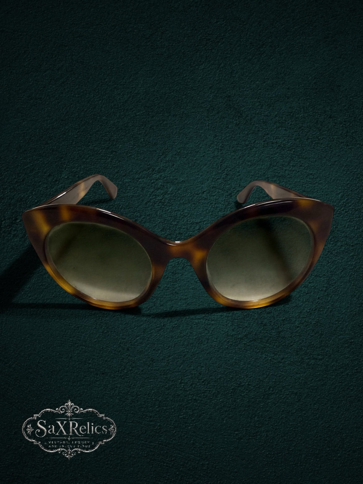 My Store Gucci tortoiseshell cat-eye sunglasses with gradient lenses on a dark green textured background