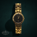 My Store vintage Gucci 3300M gold-tone wristwatch with a black dial and Roman numeral bezel on a link bracelet.