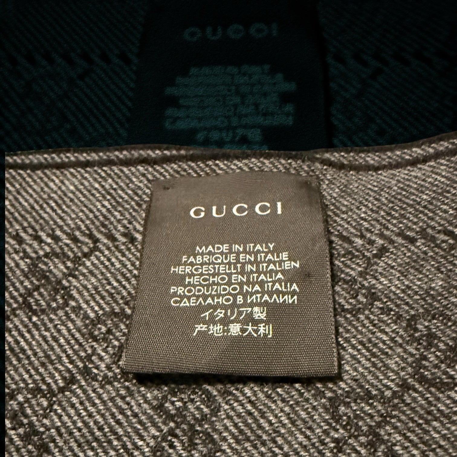 My Store Gucci wool scarf featuring the iconic grey and charcoal GG monogram pattern and a Made in Italy fabric label.