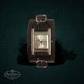 My Store GUESS rectangular silver-tone watch with crystal accents on a wide dark brown crocodile-embossed leather cuff