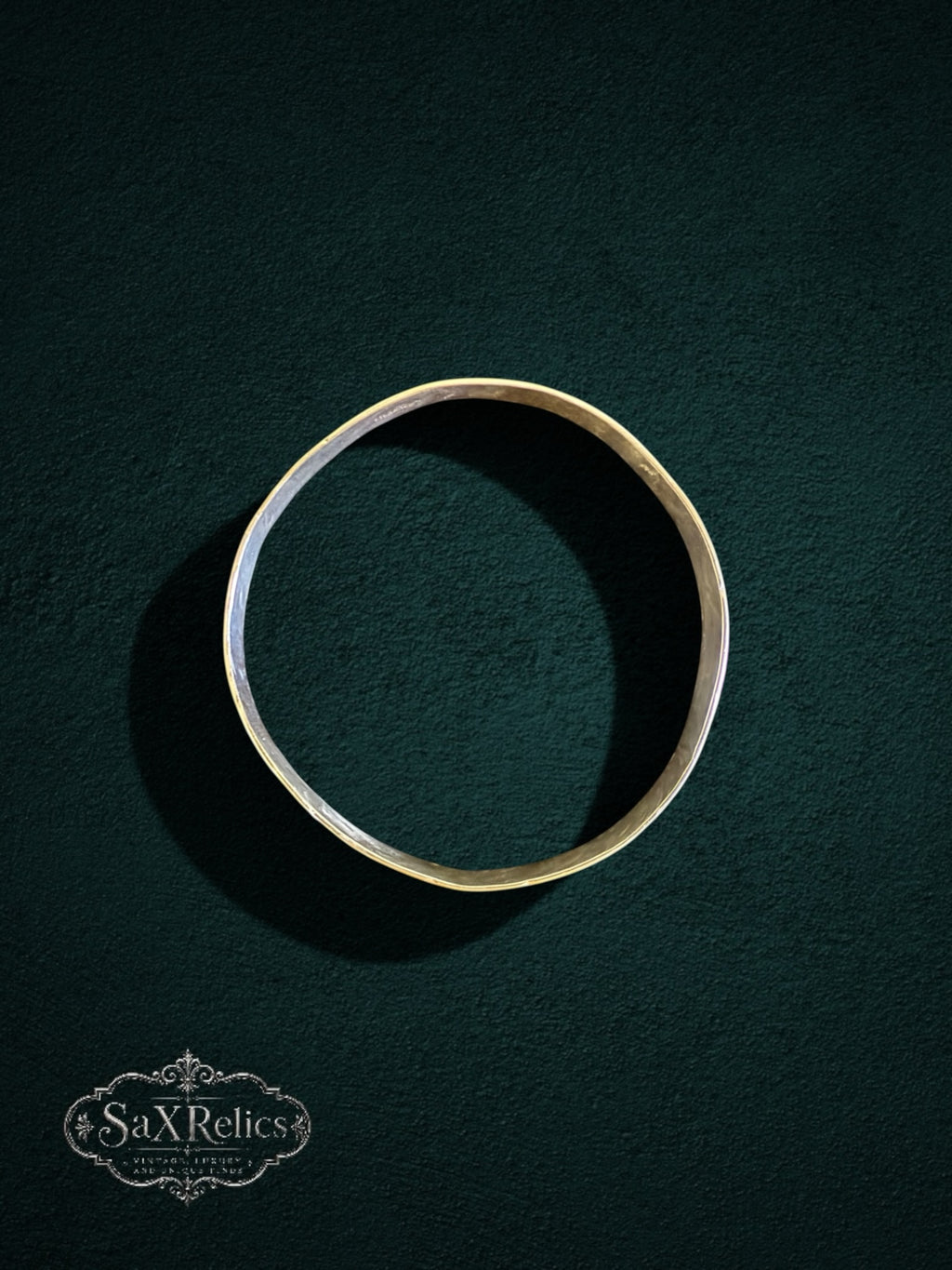 My Store handcrafted sterling silver bangle with a unique hammered texture on a dark textured background