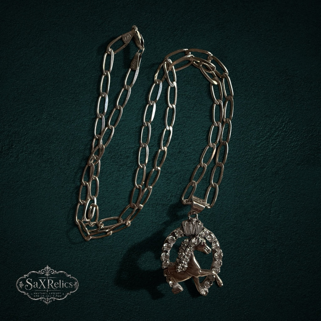 SaX Relics — Herradura sterling silver horse and horseshoe pendant on its matching link chain.