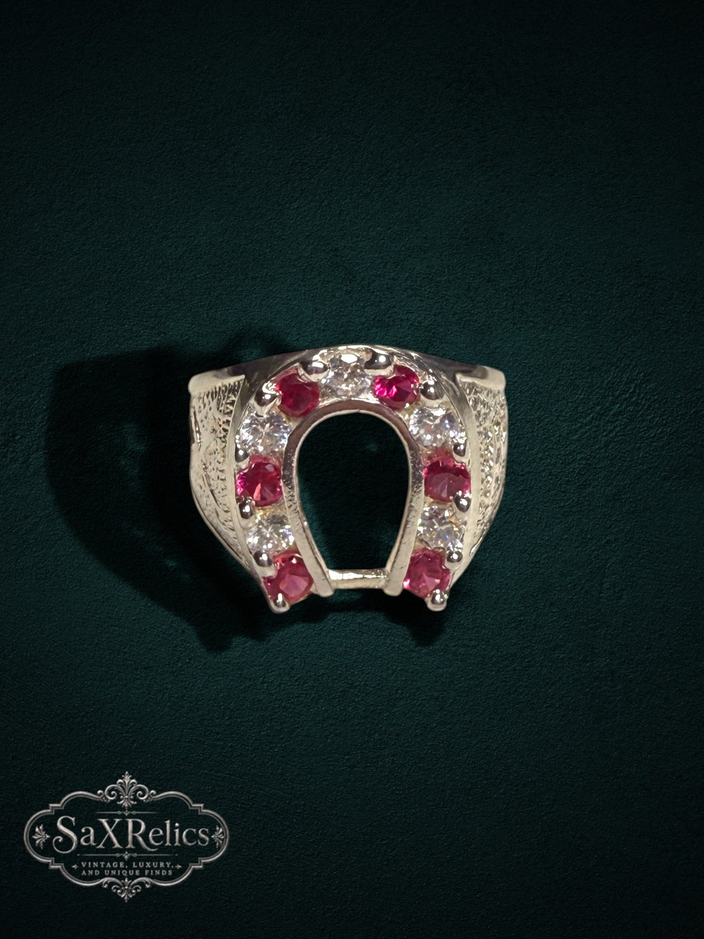 My Store sterling silver horseshoe ring featuring red rubies and clear stones with intricate textured side detailing.
