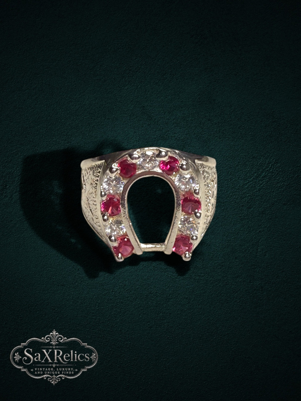 My Store sterling silver horseshoe ring featuring red rubies and clear stones with intricate textured side detailing.
