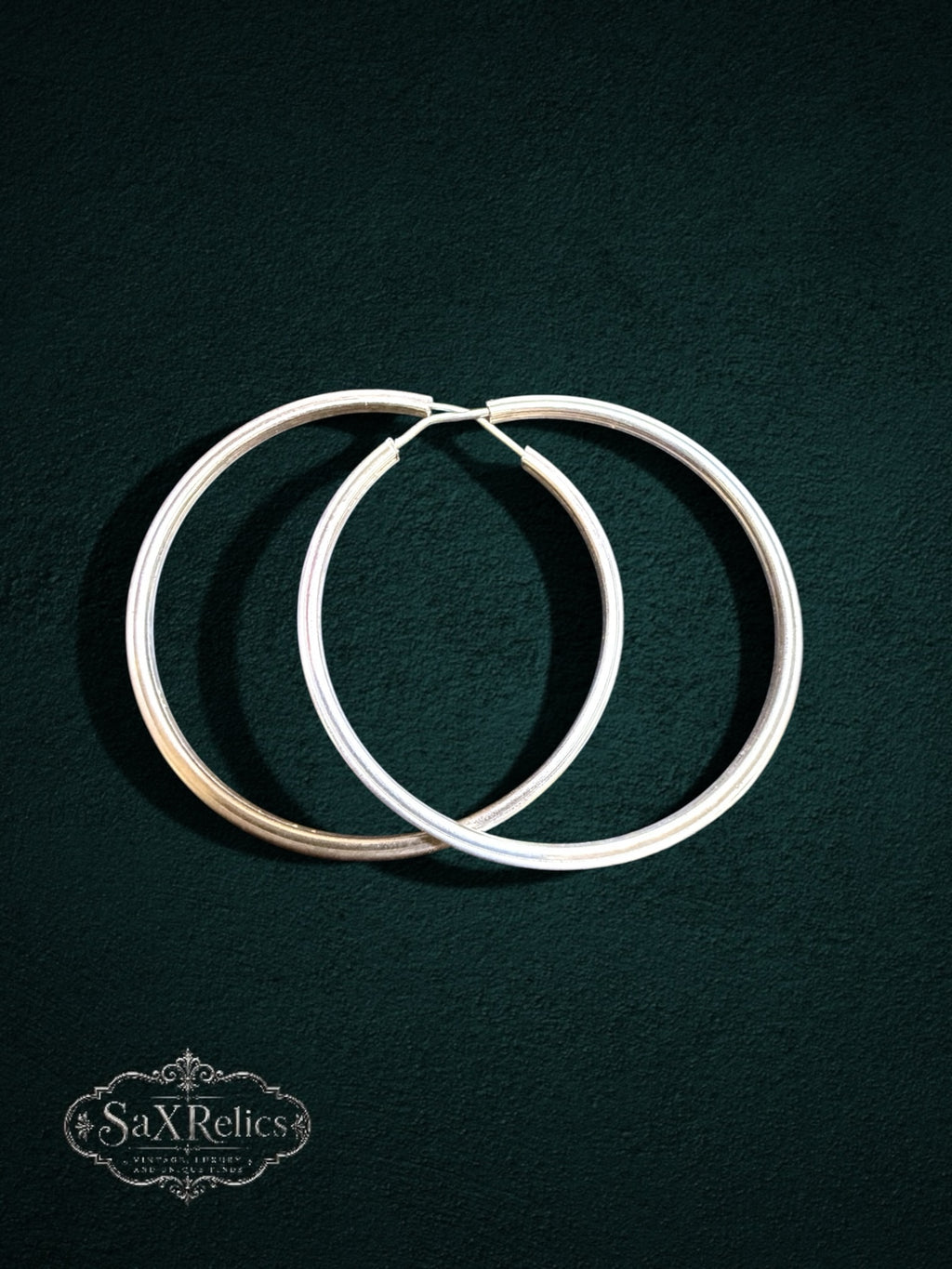 My Store SaxRelics large sterling silver hoop earrings with a delicate textured pattern on a dark background