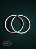 My Store SaxRelics large sterling silver hoop earrings with a delicate textured pattern on a dark background