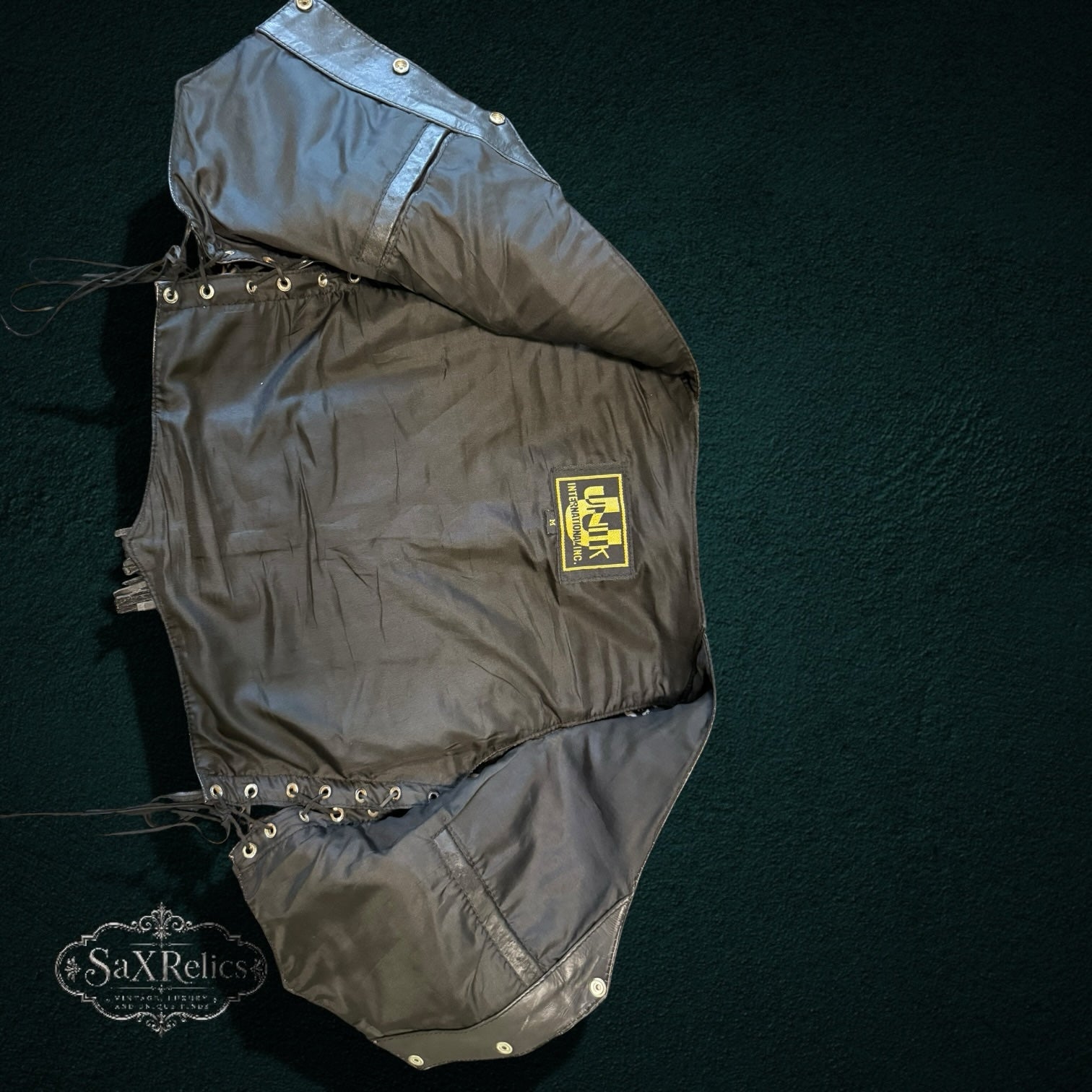 My Store black leather vest interior view showing lining, brand label, and side lace-up detailing.