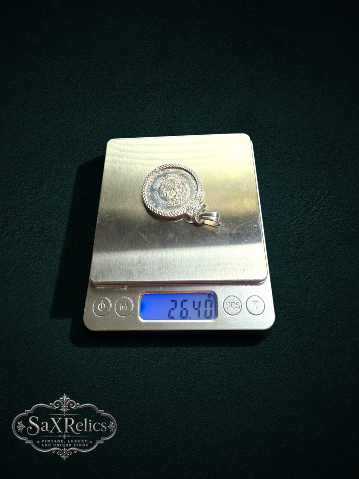 My Store vintage Mexican Cinco Pesos coin pendant in a sterling silver setting weighing 26.40 grams on a digital scale