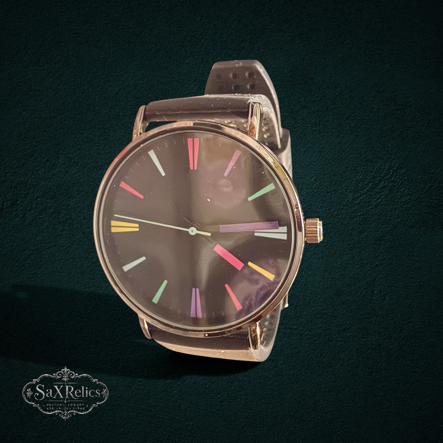 SaX Relics minimalist watch with a dark dial, multi-color hour markers, and a black silicone strap