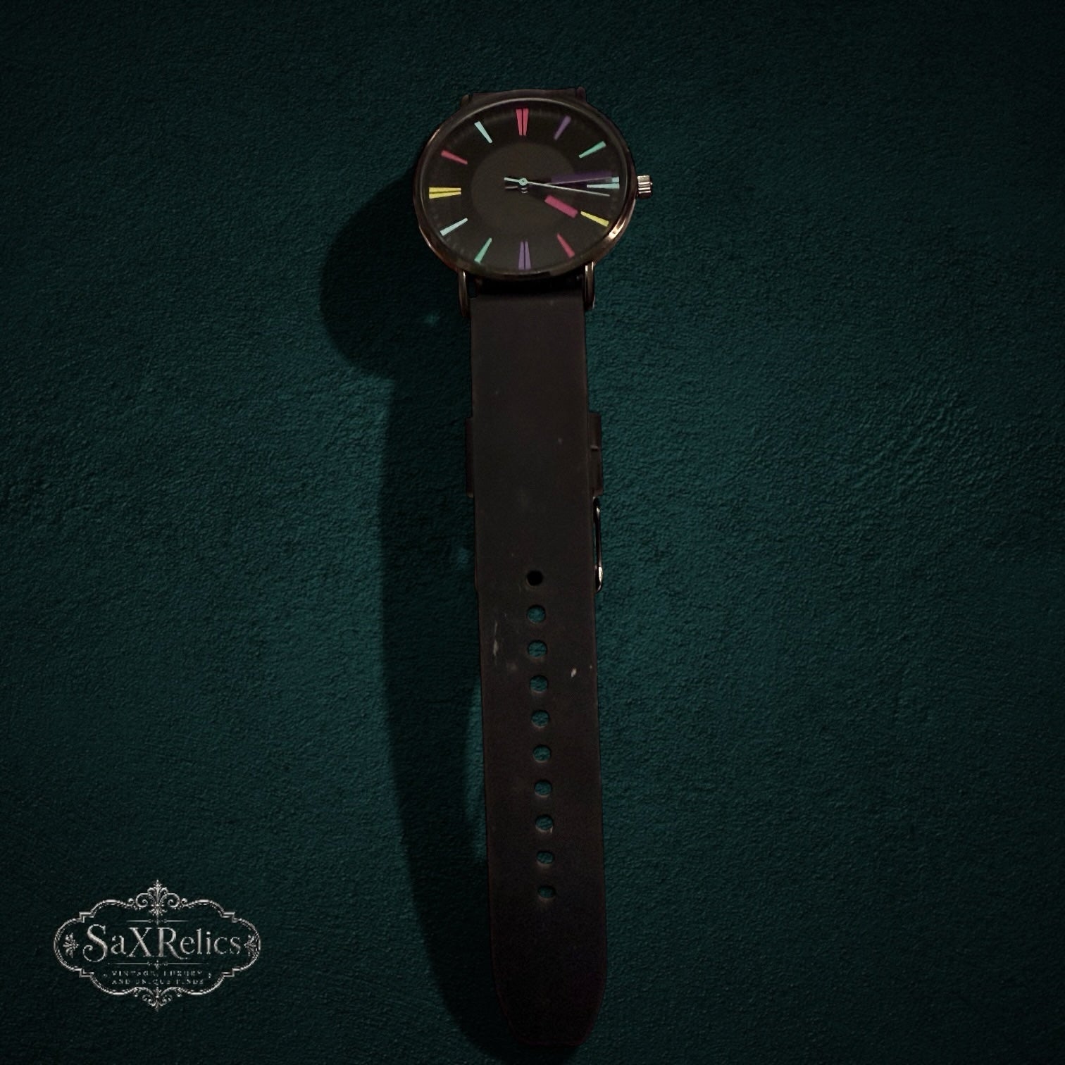SaX Relics minimalist dark dial watch showing the multi-color indices