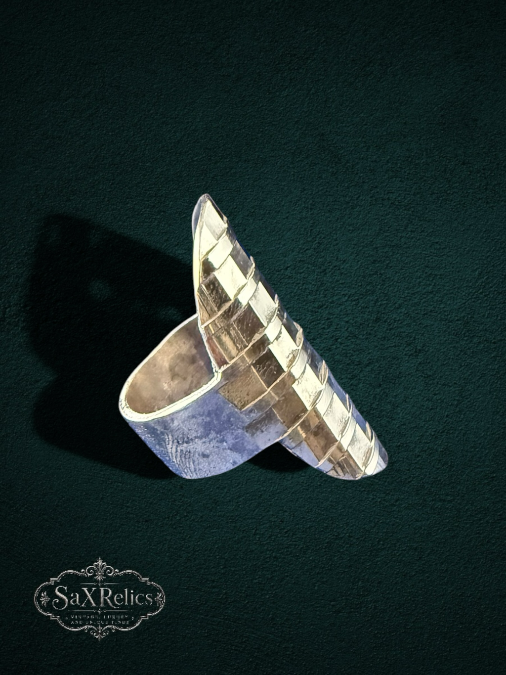 My Store modern statement ring with an elongated, architectural silhouette and a textured, grid-like metallic surface.