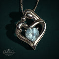 My Store sterling silver mother and child heart pendant necklace with a light blue heart-cut gemstone on a silver chain.