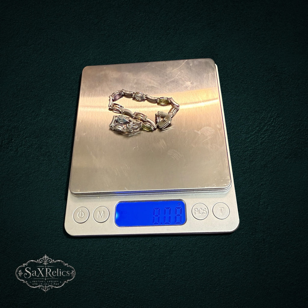My Store multi-gemstone marquise-cut link bracelet resting on a digital scale for weight measurement