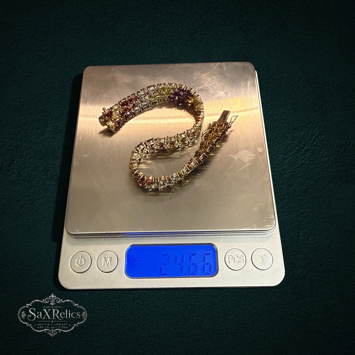 My Store multi-row gemstone link bracelet with oval-cut stones on a digital scale showing 24.66 grams weight.