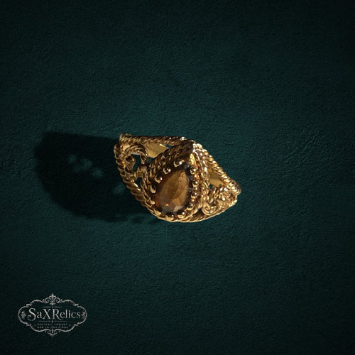 My Store SAXRelics ornate gold ring featuring a pear-cut amber gemstone with a twisted rope band and filigree detail.
