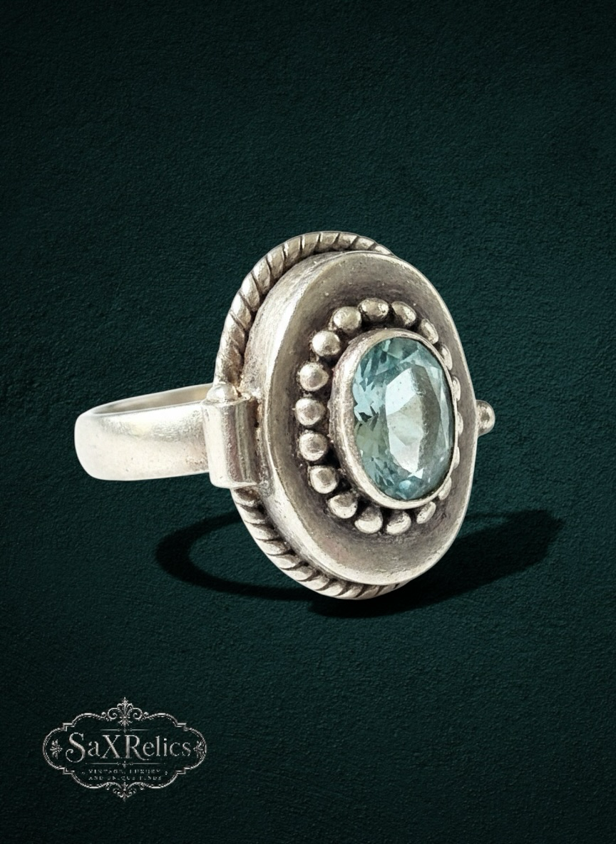 My Store ornate sterling silver hinged locket ring with an oval light blue gemstone and twisted rope border detail.
