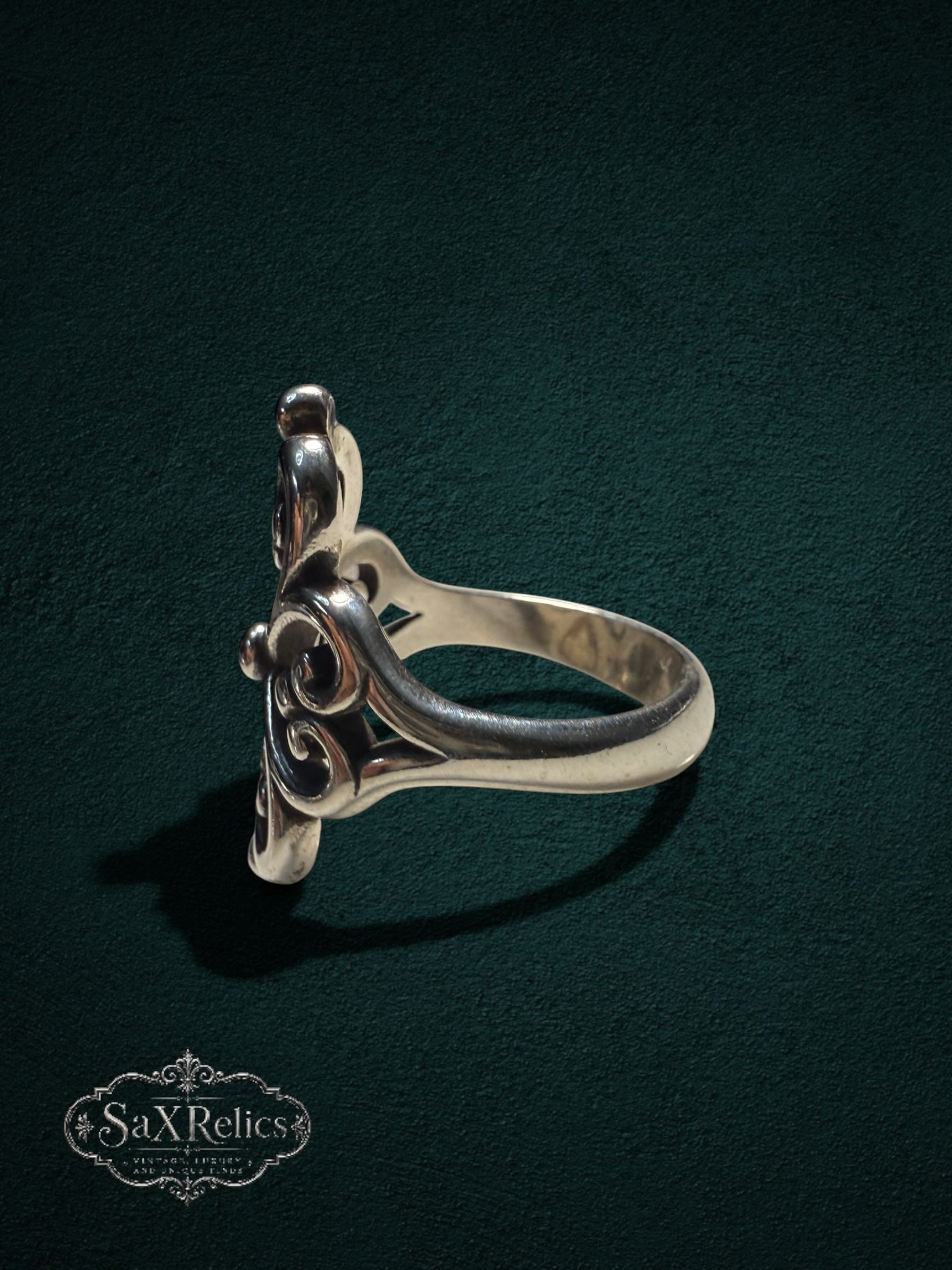 My Store sterling silver statement ring with intricate filigree scrollwork and polished finish on dark background