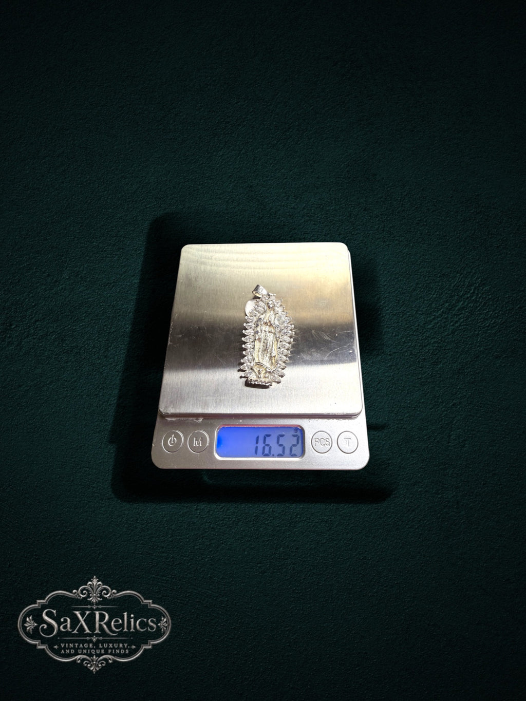 My Store sterling silver Our Lady of Guadalupe pendant with marquise-cut stones on a digital scale weighing 16.52g