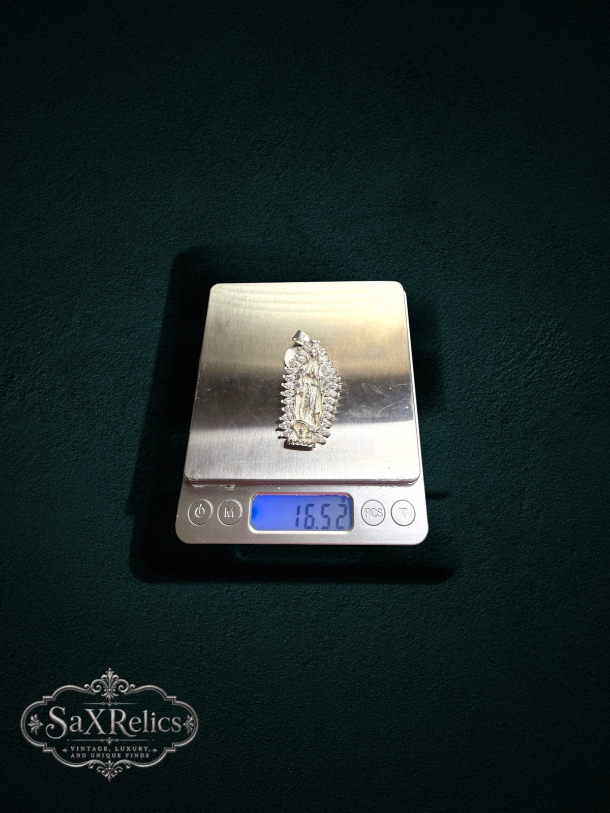 My Store sterling silver Our Lady of Guadalupe pendant with marquise-cut stones on a digital scale weighing 16.52g