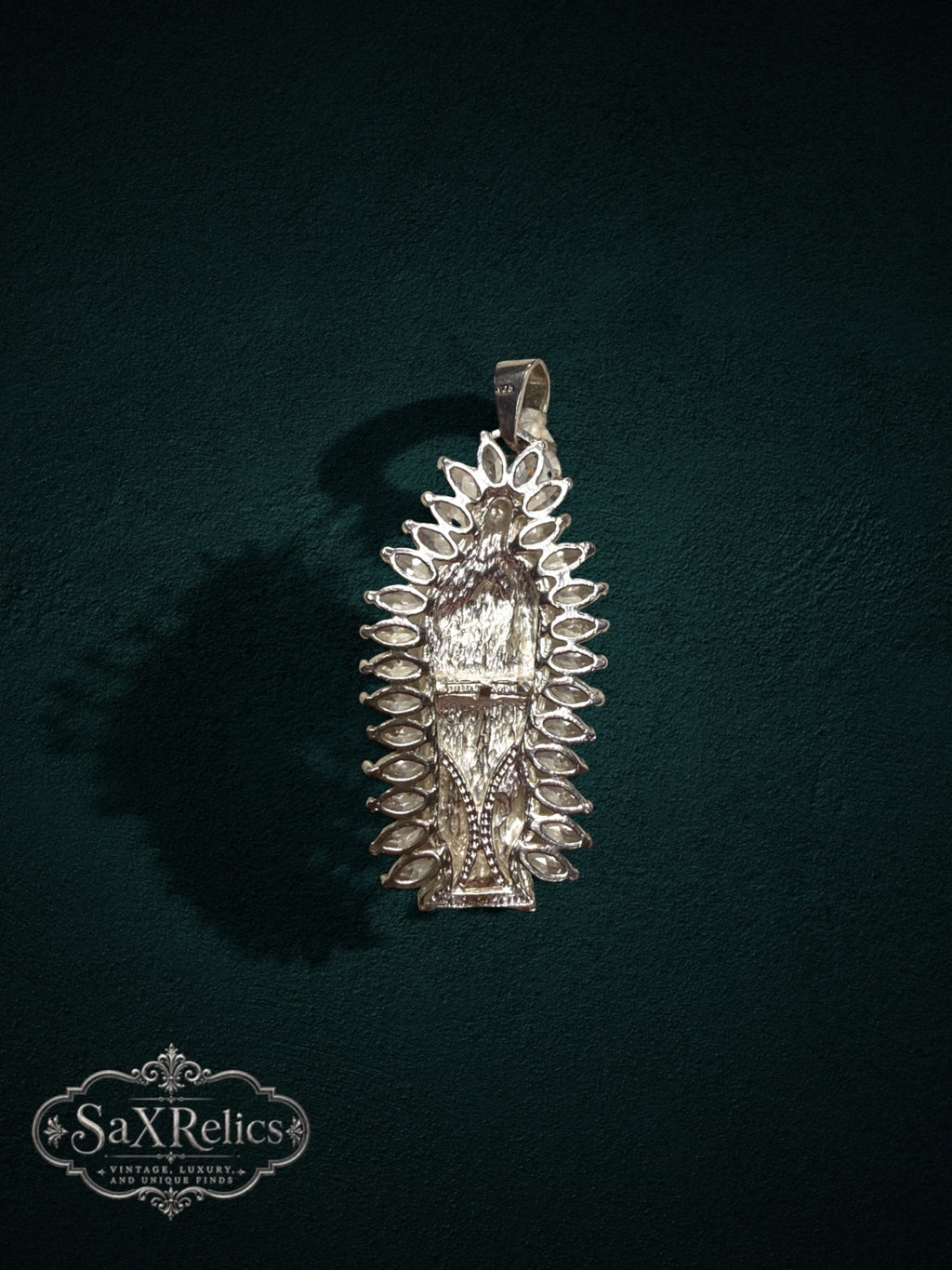 My Store Our Lady of Guadalupe silver-tone pendant with marquise-cut stone halo on a dark green background
